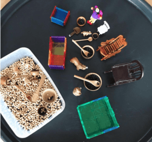  A sensory play setup for "Goldilocks and the Three Bears" features animal figures, including bears, as props for storytelling. Magnetic tiles were used to create beds. 