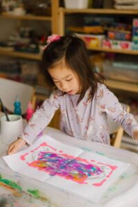 A child doing process art in a white paper