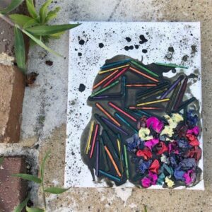 A collage of colorful pieces on an existing black canvas artwork, showcasing a layered and textured masterpiece created by a toddler