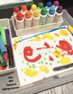 Brightly colored dot markers arranged in a row as an invitation for toddlers to use in stamping and creating vibrant artwork.